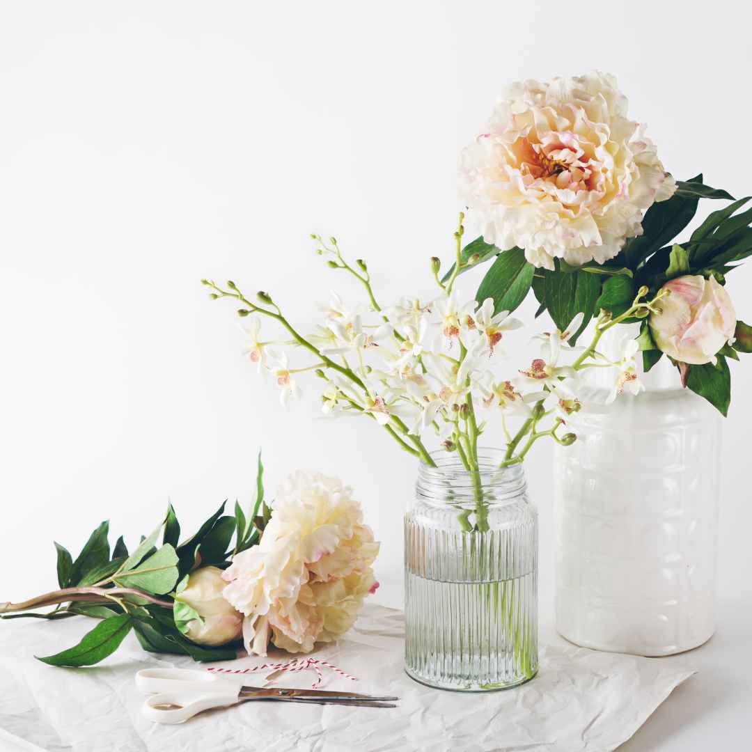 1 gefüllte Pastell-Rose in Vase. 2 weitere Rosen daneben liegend.