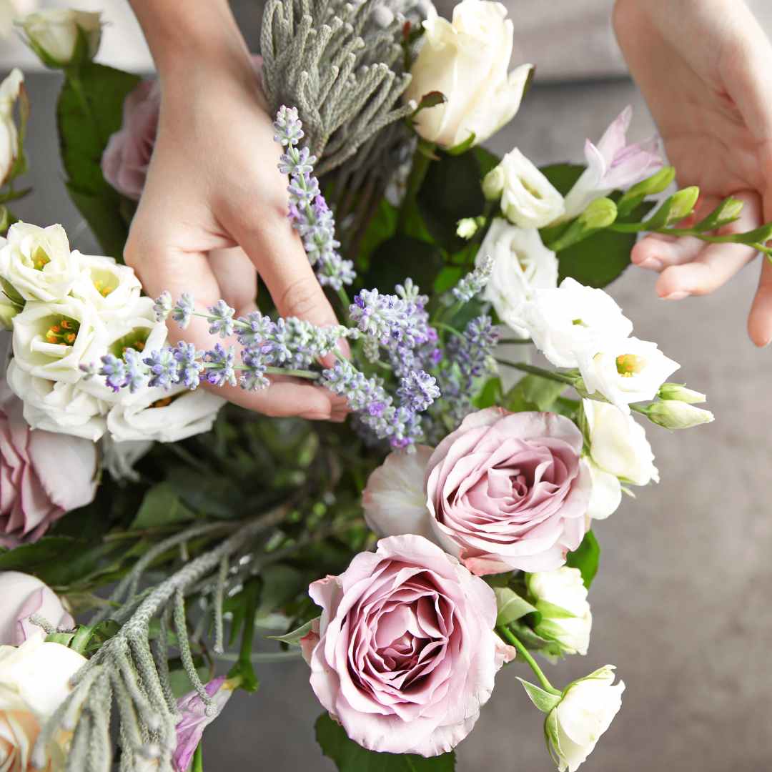 Nahaufnahme eines fertigen Blumenstraußes mit pastellfarbenen Rosen, Eustoma und lila Lavendel.